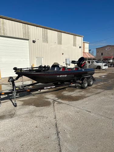 Slide: The Image of 2003 Skeeter SX 200 boat on a trailer outside a warehouse. - 2