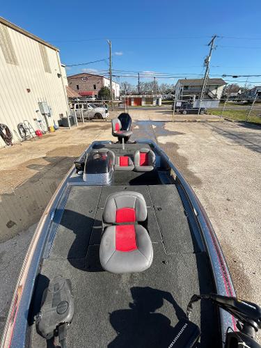 Slide: The Image of 2003 Skeeter SX 200 fishing boat with red and gray seats in a parking lot. - 23