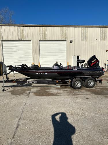 Slide: The Image of 2003 Skeeter SX 200 boat on a trailer in front of a garage. - 3