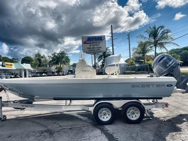 Slide: The Image of 2023 Skeeter SX210 boat on trailer, displayed outdoors at dealership. - 1