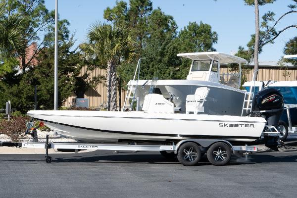 Slide: The Image of 2024 Skeeter SX 210 boat on a trailer in a parking lot. - 2