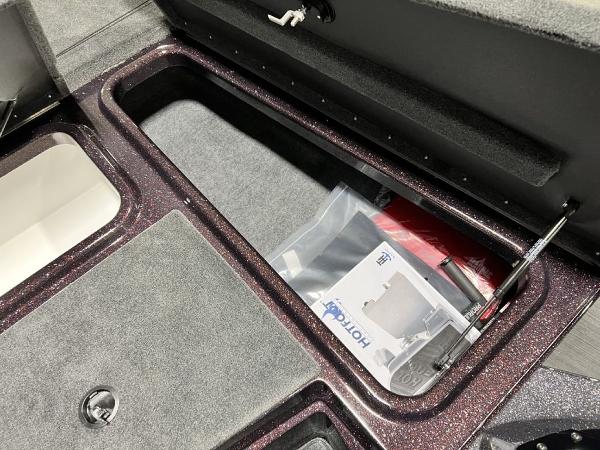 Slide: The Image of 2024 Skeeter ZX150 storage compartment with manuals and accessories. - 10