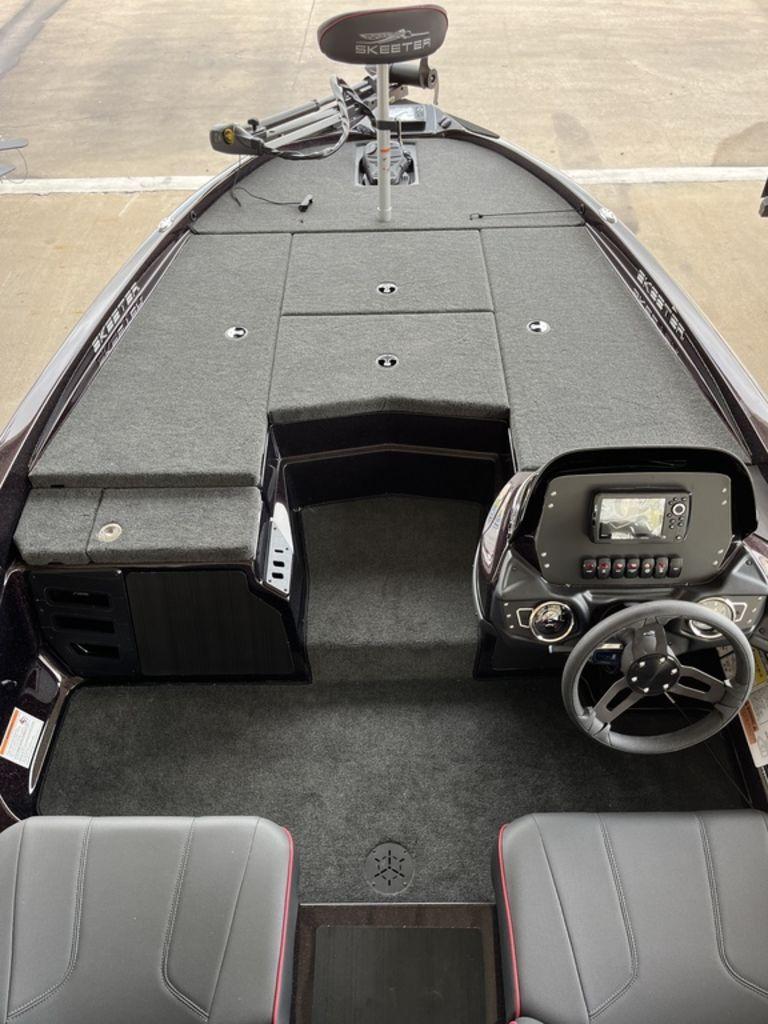 Slide: The Image of 2024 Skeeter ZX150 boat interior with steering console and seating. - 2