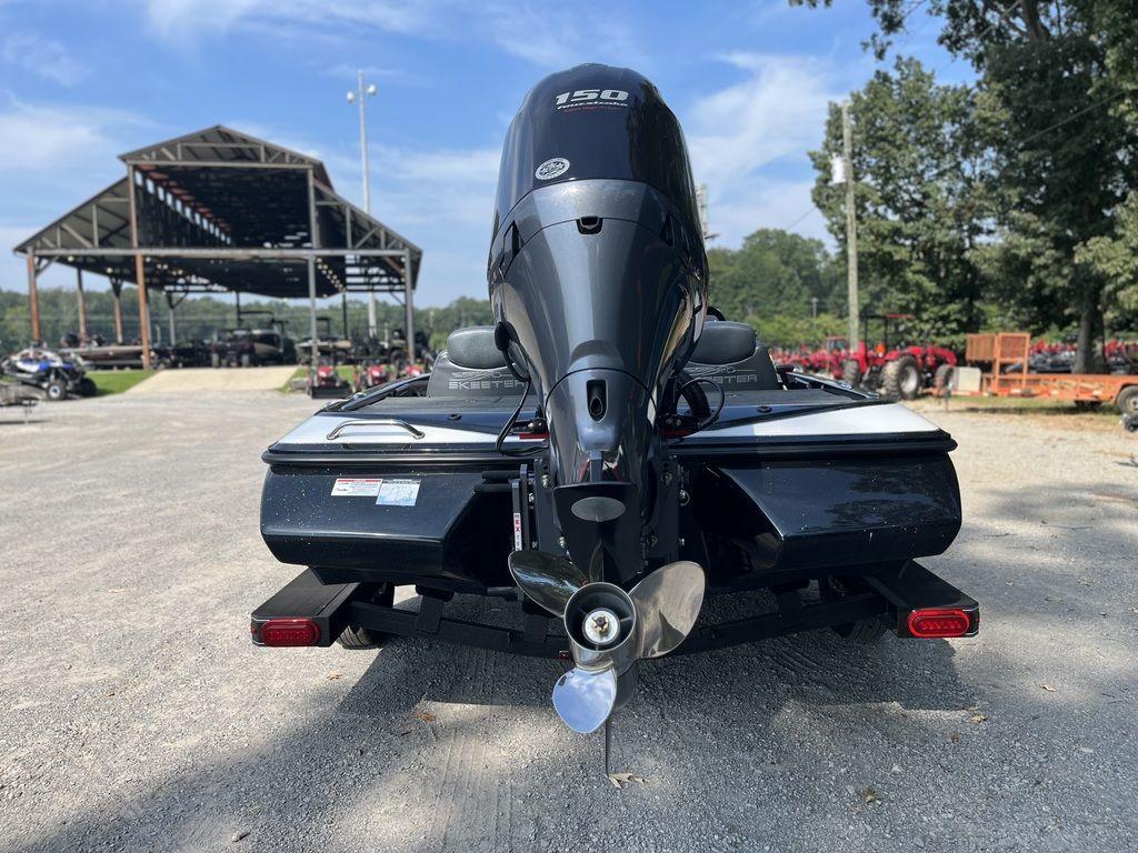 Slide: The Image of 2024 Skeeter ZX150 boat rear view with outboard motor in a dealership lot. - 3
