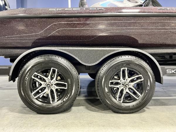 Slide: The Image of 2024 Skeeter ZX150 boat trailer with dual black alloy wheels. - 4