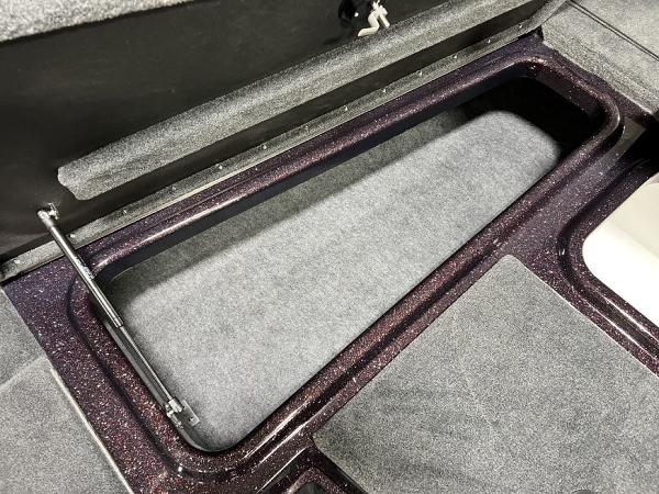 Slide: The Image of 2024 Skeeter ZX150 boat storage compartment with carpeted interior. - 8