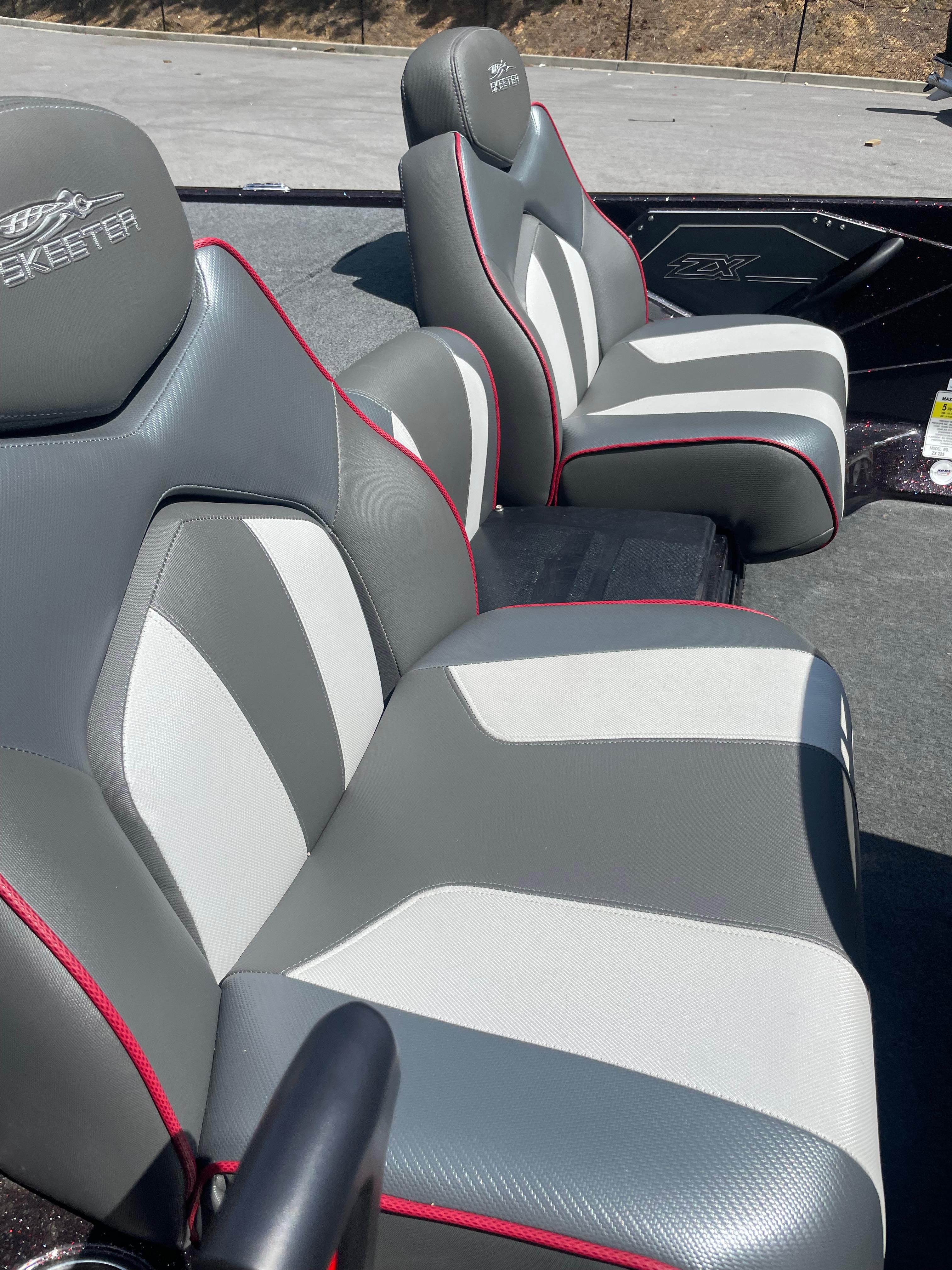 Slide: The Image of 2020 Skeeter ZX 225 boat seats with gray and white upholstery, red accents. - 6