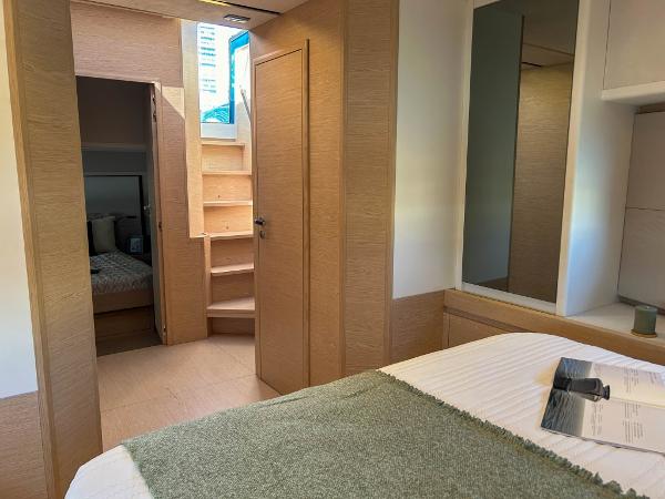 Slide: The Image of Interior cabin of 2024 Solaris Power 52 Open yacht with wooden finishes and cozy bedding. - 15