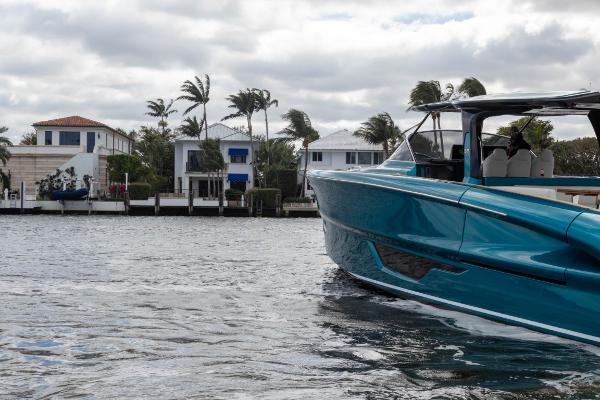 Slide: The Image of 2024 Solaris Power 52 Open yacht cruising near waterfront homes. - 7