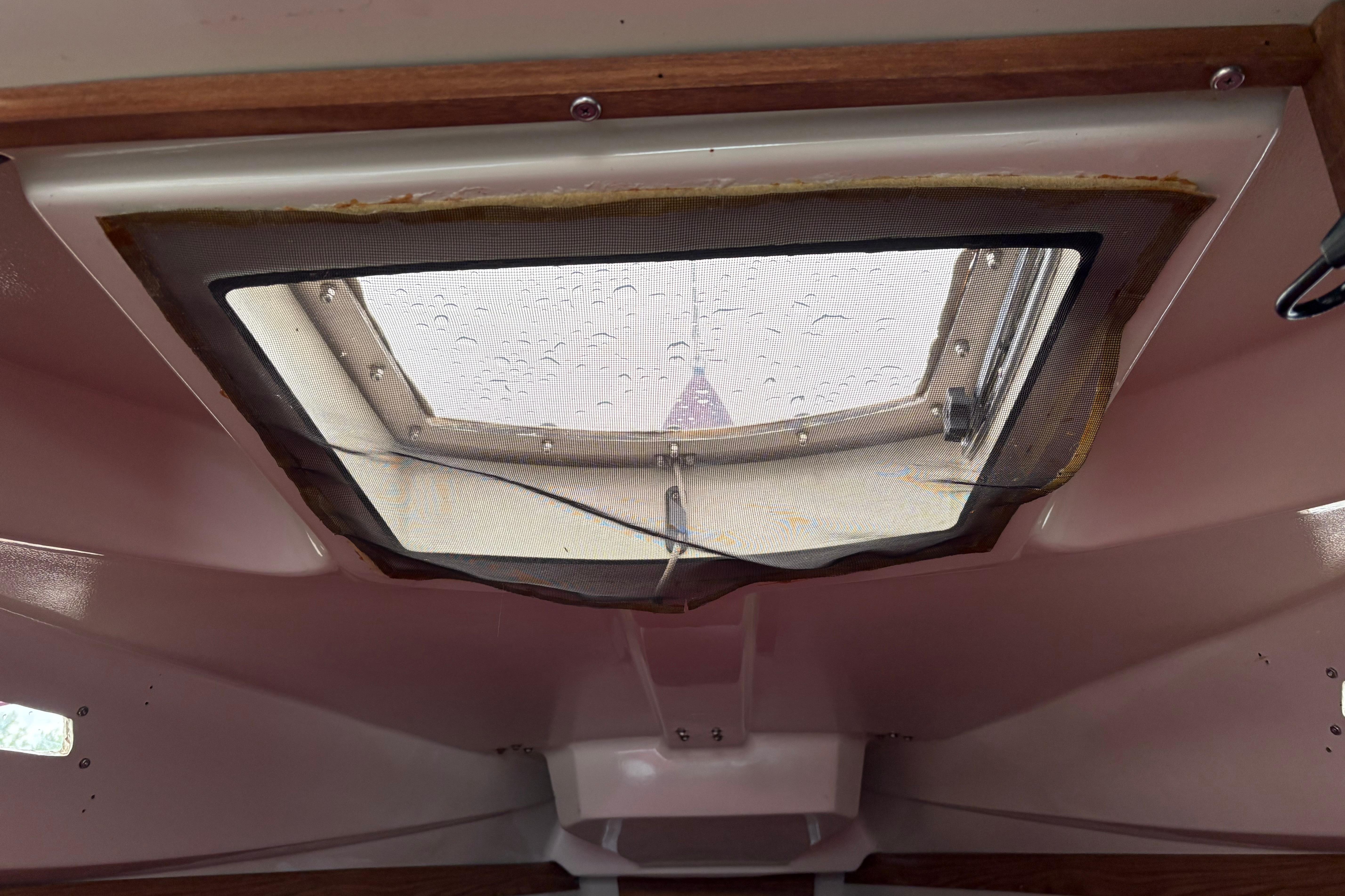 Slide: The Image of Interior view of a 1983 Sonic 23 boat hatch with raindrops on the window. - 24