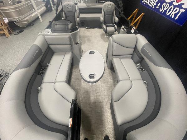 Slide: The Image of 2023 South Bay S224 UL pontoon boat interior with gray seating and central table. - 6