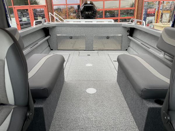 Slide: The Image of 2024 Spartan 200 Astoria boat interior with gray seating and storage compartments. - 15