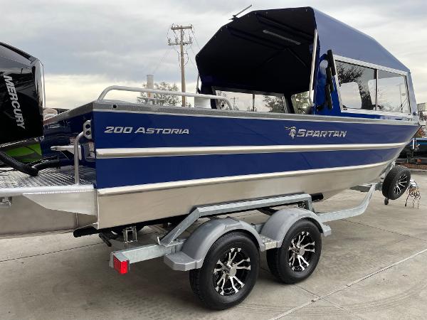 Slide: The Image of 2024 Spartan 200 Astoria boat on trailer, blue and silver, with Mercury outboard motor. - 4