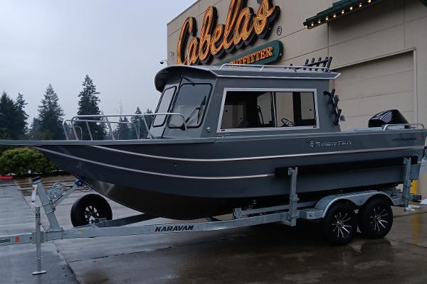 Slide: The Image of 2024 Spartan 220 Maximus Pro boat on Karavan trailer outside Cabela's store. - 0