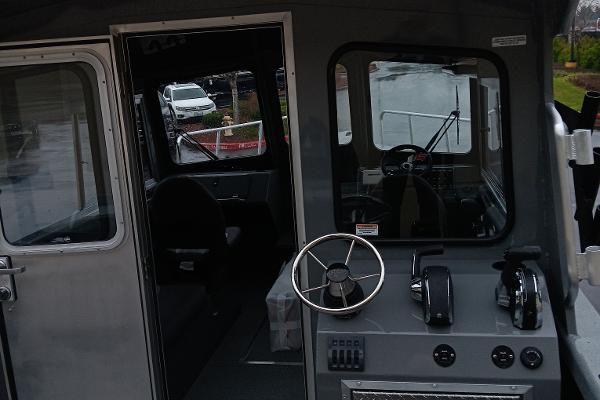 Slide: The Image of Interior cockpit view of 2024 Spartan 220 Maximus Pro boat with steering wheel and controls. - 5