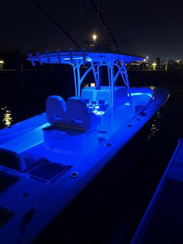 Slide: The Image of 2018 Spectre 35 Center Console by Pilini illuminated at night with blue LED lights. - 4