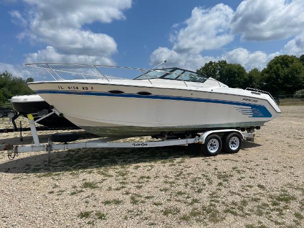Slide: The Image of 1995 Sport-Craft 2500 AVANZA boat on a trailer under a partly cloudy sky. - 2