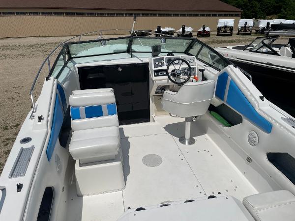 Slide: The Image of 1995 Sport-Craft 2500 AVANZA boat interior with white and blue seating, steering wheel, and dashboard. - 5