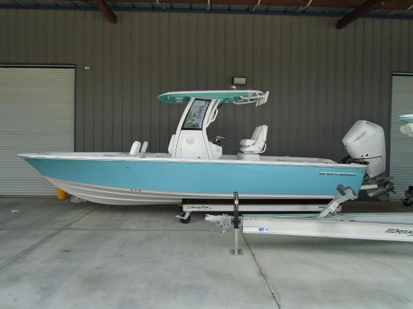 Slide: The Image of 2024 Sportsman 267 boat in blue and white, parked on a trailer in a garage. - 1
