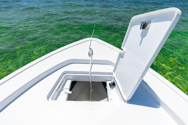 Slide: The Image of 2024 Sportsman Masters 247 Bay Boat anchor locker open on clear water. - 3