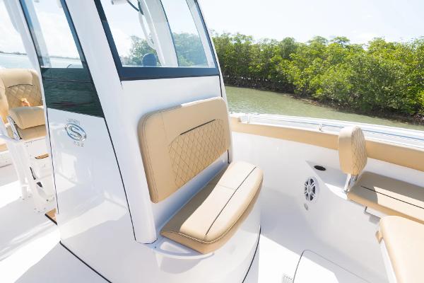 Slide: The Image of Manufacturer Provided Image: 2025 Sportsman Open 232 Center Console boat interior with tan seating and lush greenery backdrop. - 5