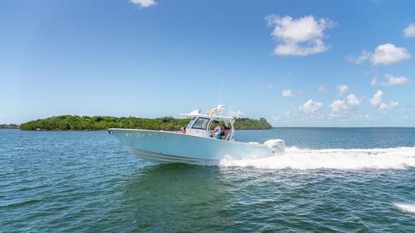 Slide: The Image of 2024 Sportsman Open 322 boat cruising on clear blue water. - 3
