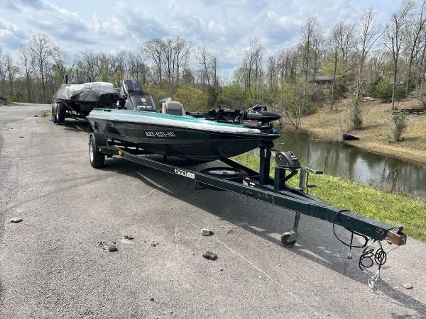 Slide: The Image of 1999 Sprint 286 Pro boat on trailer near a lake, ready for transport. - 6