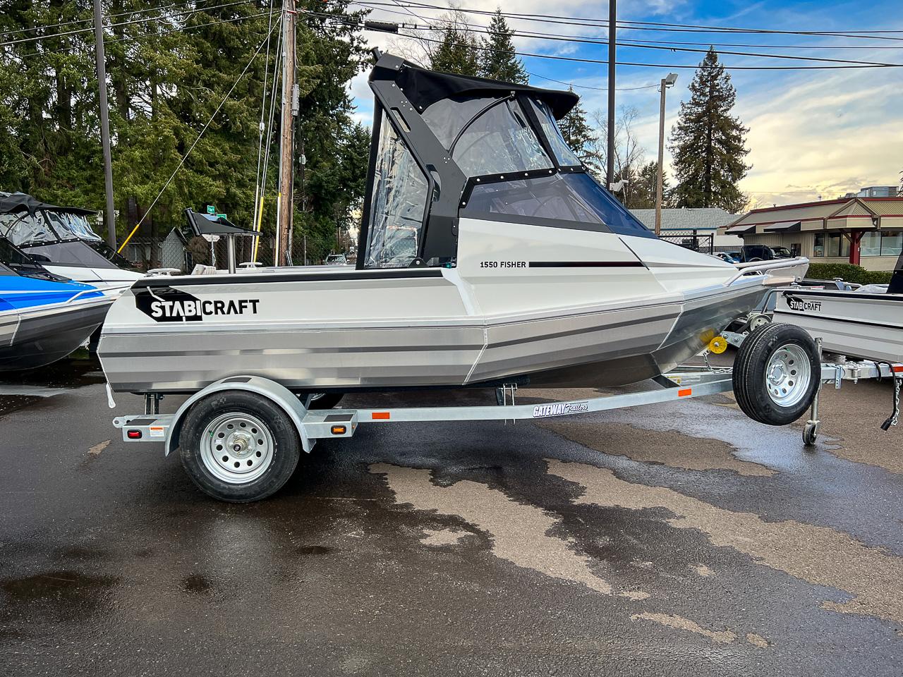 Slide: The Image of 2024 Stabicraft 1550 Fisher boat on a trailer, parked outdoors. - 2