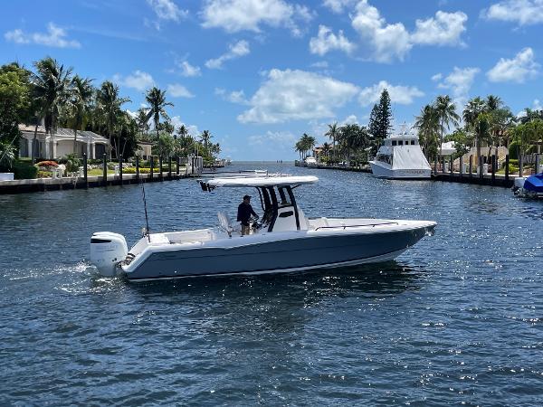 Slide: The Image of 2023 Stamas 31T Aventura boat cruising on a sunny canal with palm trees. - 0