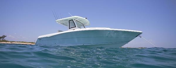 Slide: The Image of 2023 Stamas 31T Aventura boat anchored in clear blue water. - 12