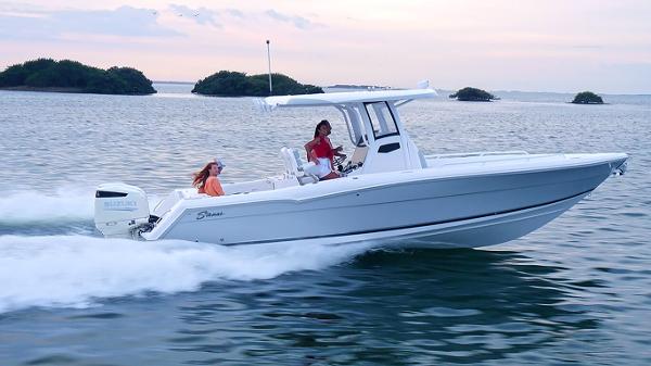Slide: The Image of 2023 Stamas 31T Aventura boat cruising on open water at sunset. - 13