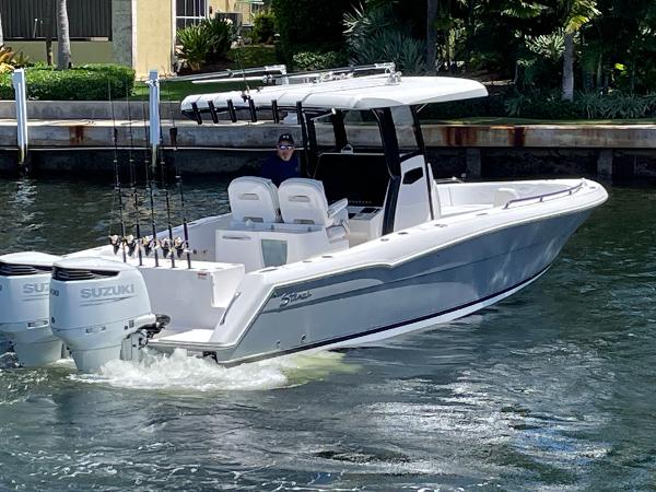 Slide: The Image of 2023 Stamas 31T Aventura boat with dual Suzuki engines cruising on water. - 2