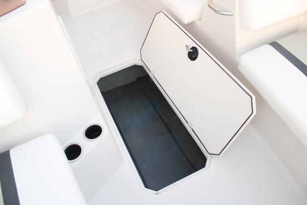 Slide: The Image of 2024 Starcraft 171 SVX boat storage compartment with open hatch and cup holders. - 10