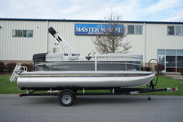 Slide: The Image of 2024 Starcraft LX 20 R pontoon boat on a trailer outside Master Marine Boat Center. - 1