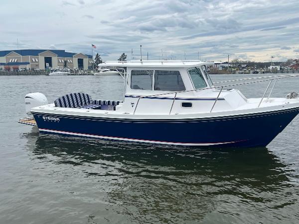 Slide: The Image of 2025 Steiger Craft 255 Annapolis boat on water, blue hull, overcast sky. - 0