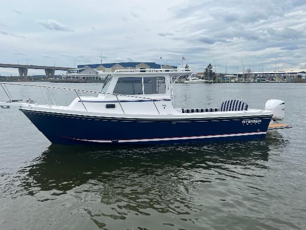 Slide: The Image of 2025 Steiger Craft 255 Annapolis boat on calm water, overcast sky. - 7