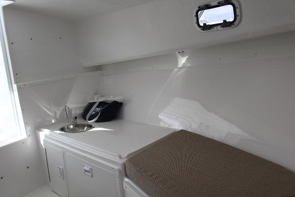Slide: The Image of 2024 Steiger Craft 31 Miami cabin interior with sink and storage. - 30