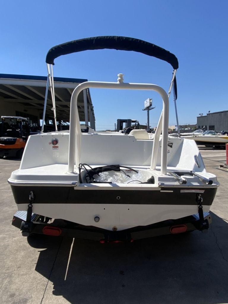 Slide: The Image of 2024 Stingray 172SC boat rear view with bimini top in a marina. - 3