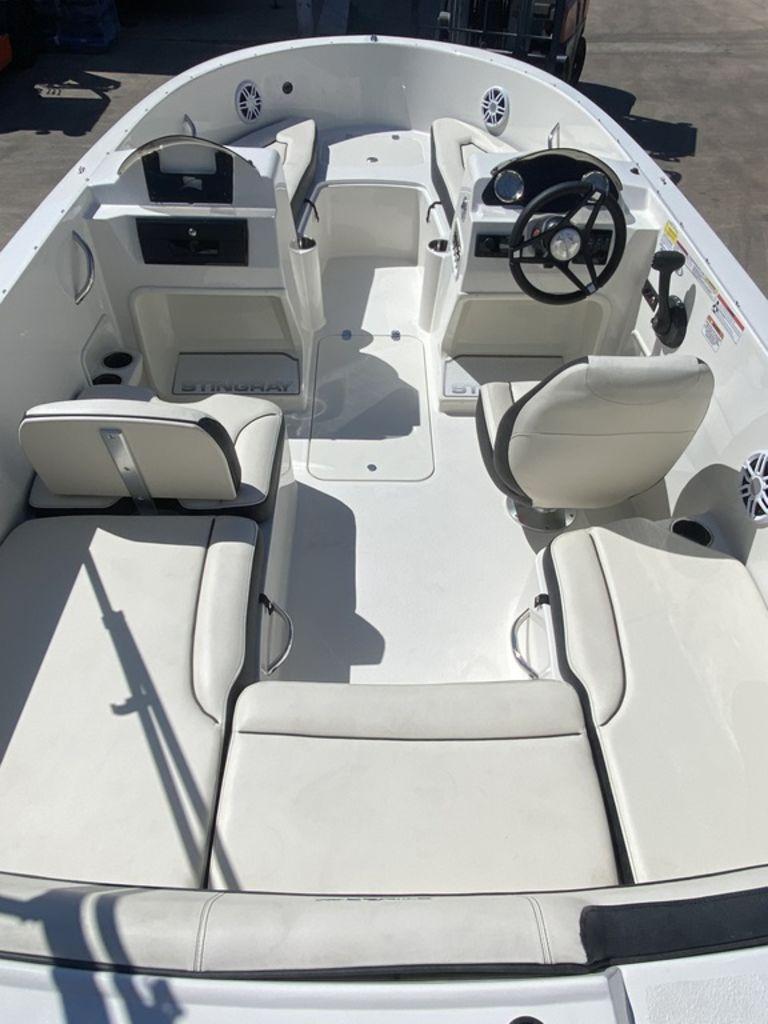 Slide: The Image of 2024 Stingray 172SC boat interior with white seating and steering console. - 4
