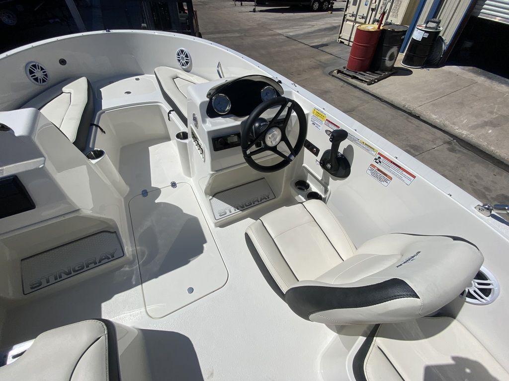 Slide: The Image of 2024 Stingray 172SC boat interior with white seating and steering console. - 6