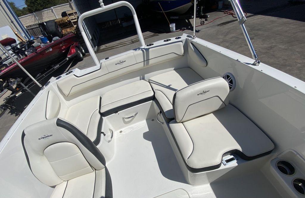 Slide: The Image of 2024 Stingray 172SC boat interior with white cushioned seating and storage compartments. - 7