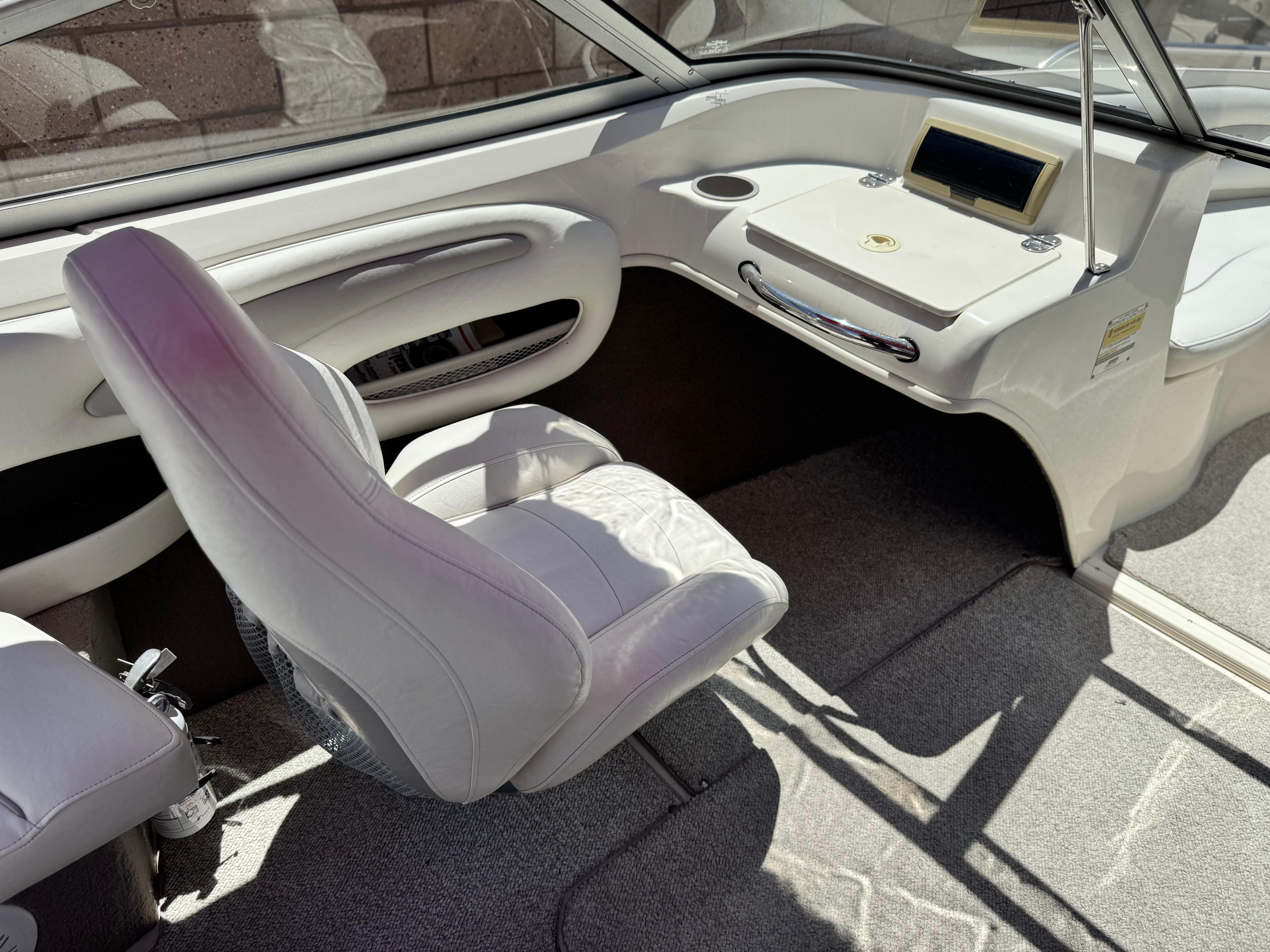Slide: The Image of Interior of a 2006 Stingray 195 LR boat with white seating and dashboard. - 10
