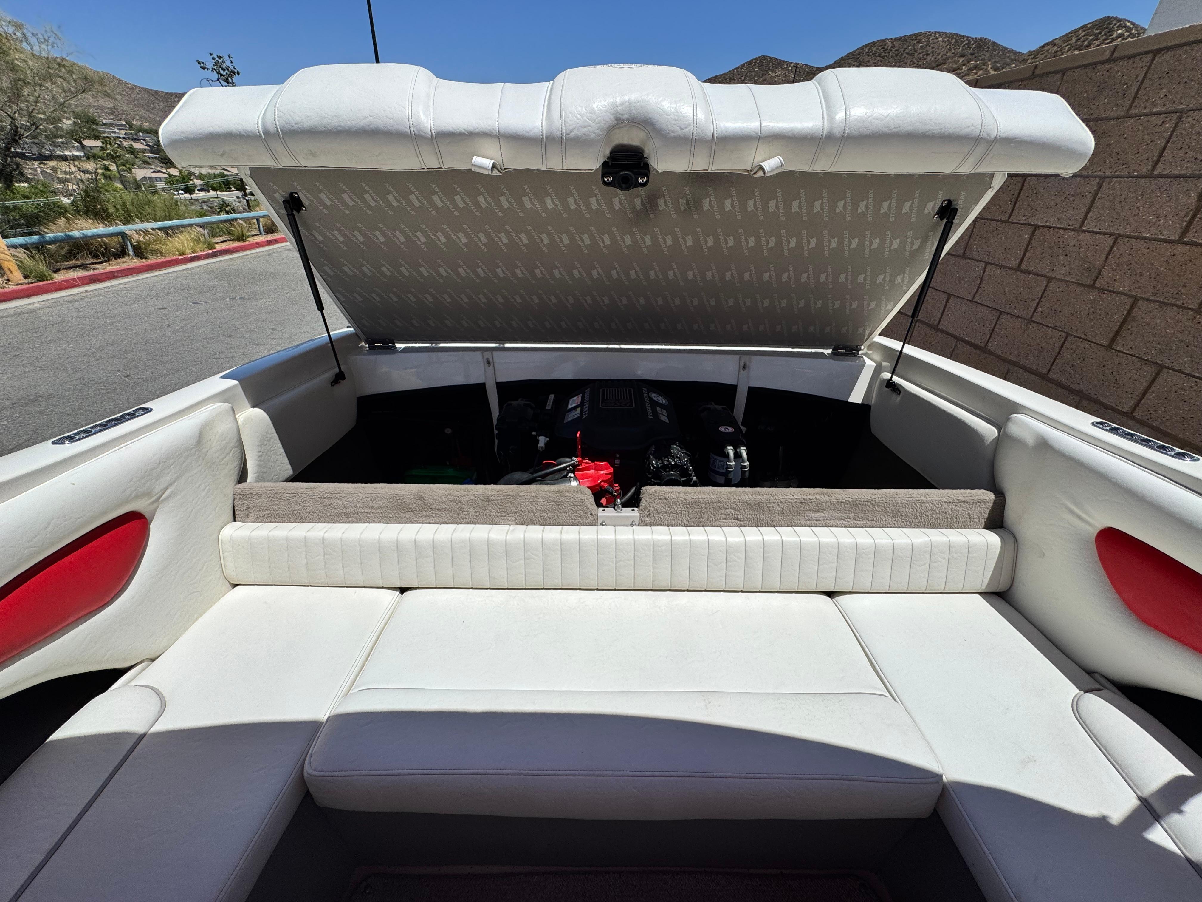 Slide: The Image of 2006 Stingray 195 LR boat interior with open engine compartment, white seating, and red accents. - 13