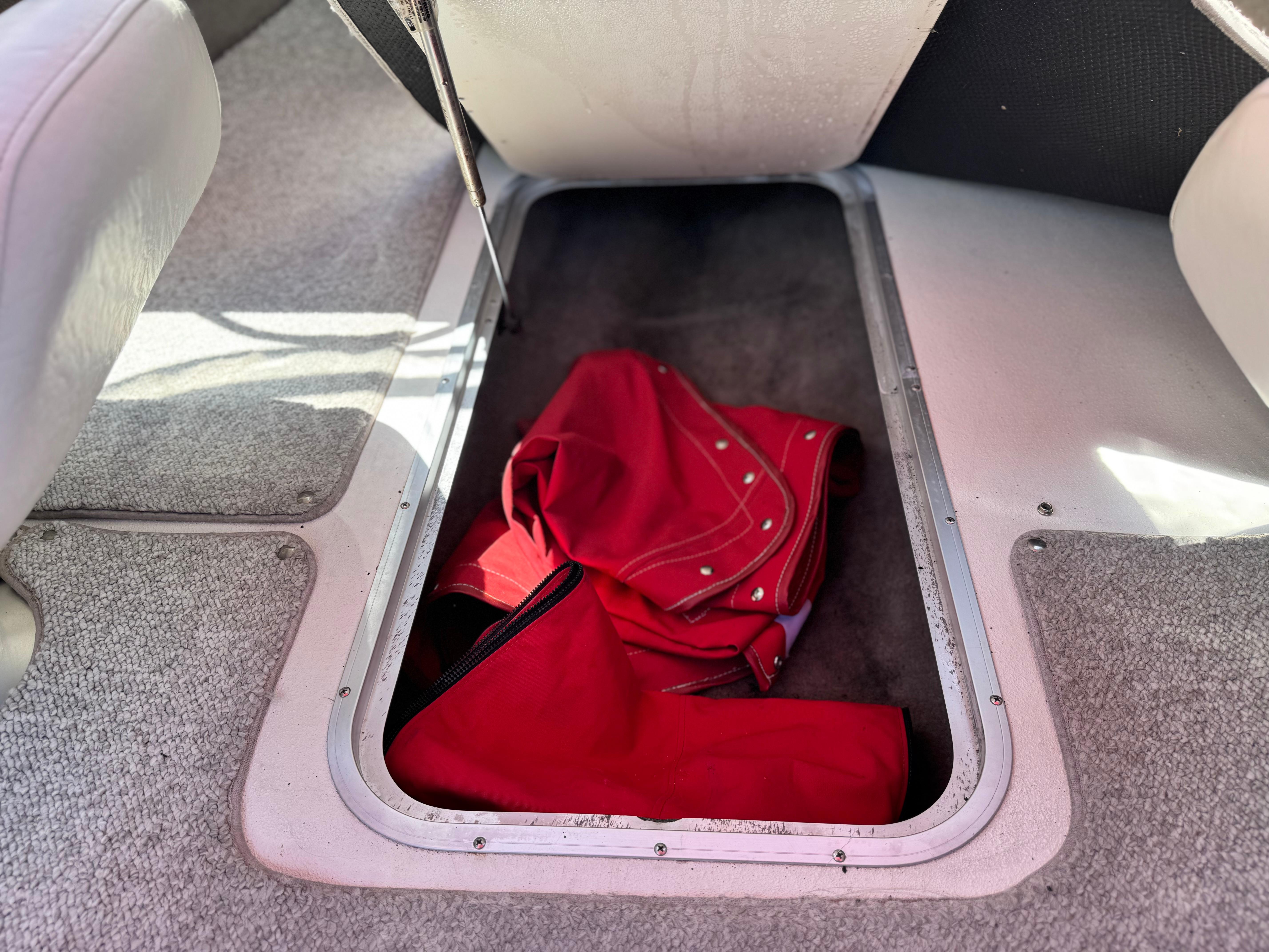 Slide: The Image of Storage compartment in 2006 Stingray 195 LR boat with red cover inside. - 16