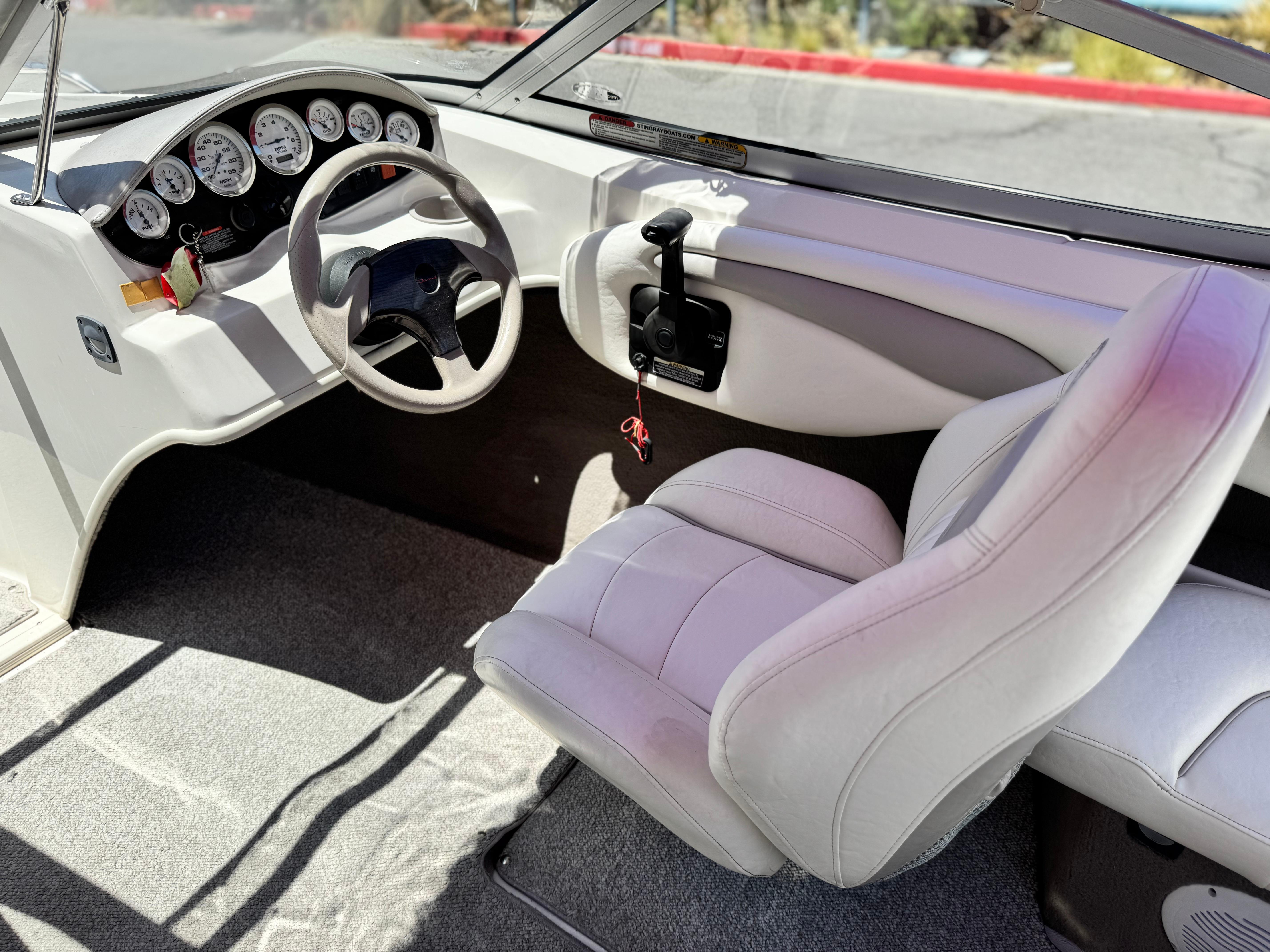 Slide: The Image of Interior of a 2006 Stingray 195 LR boat, featuring steering wheel and dashboard controls. - 17