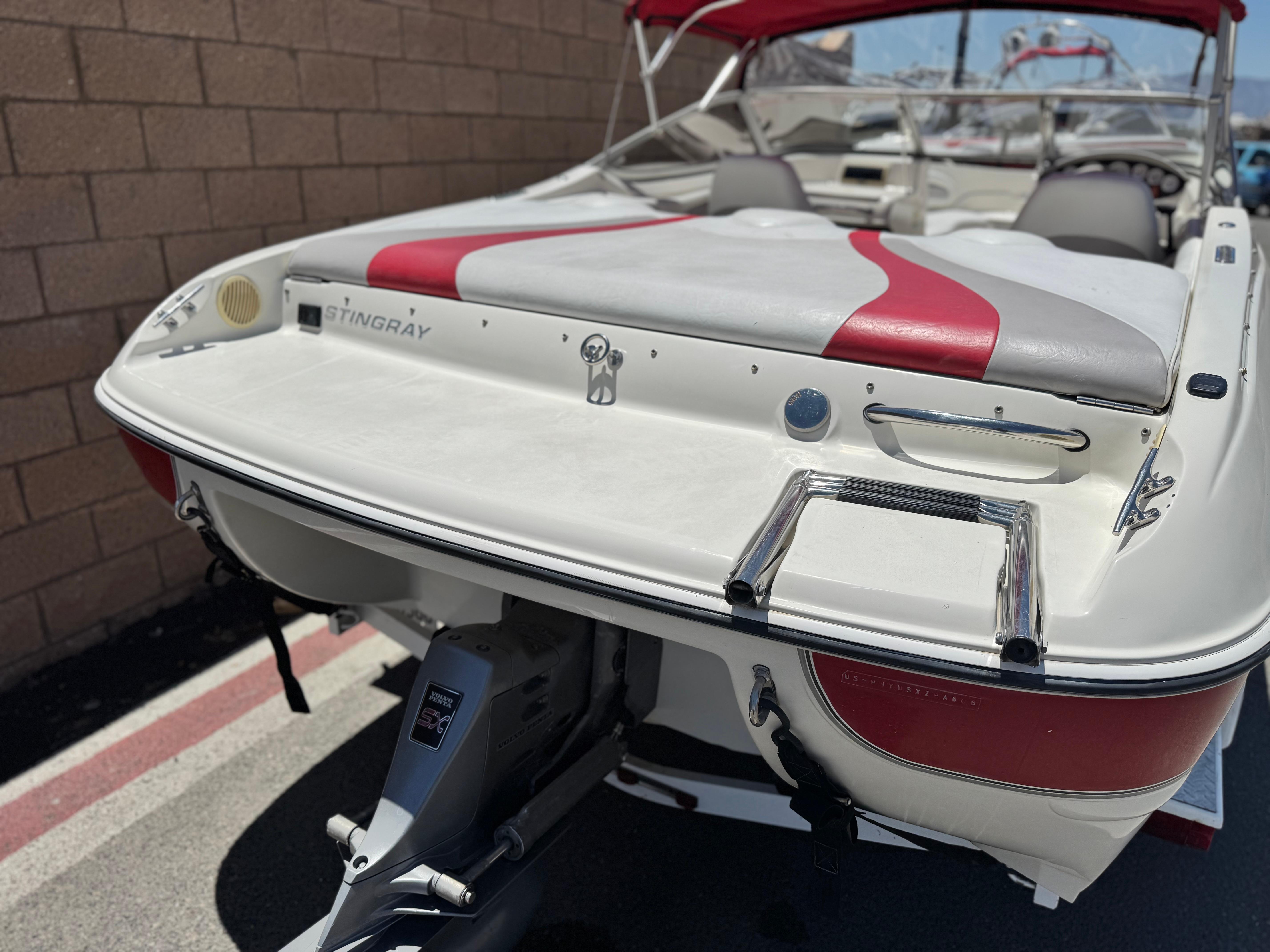 Slide: The Image of 2006 Stingray 195 LR boat with red and white upholstery, parked on a trailer. - 6
