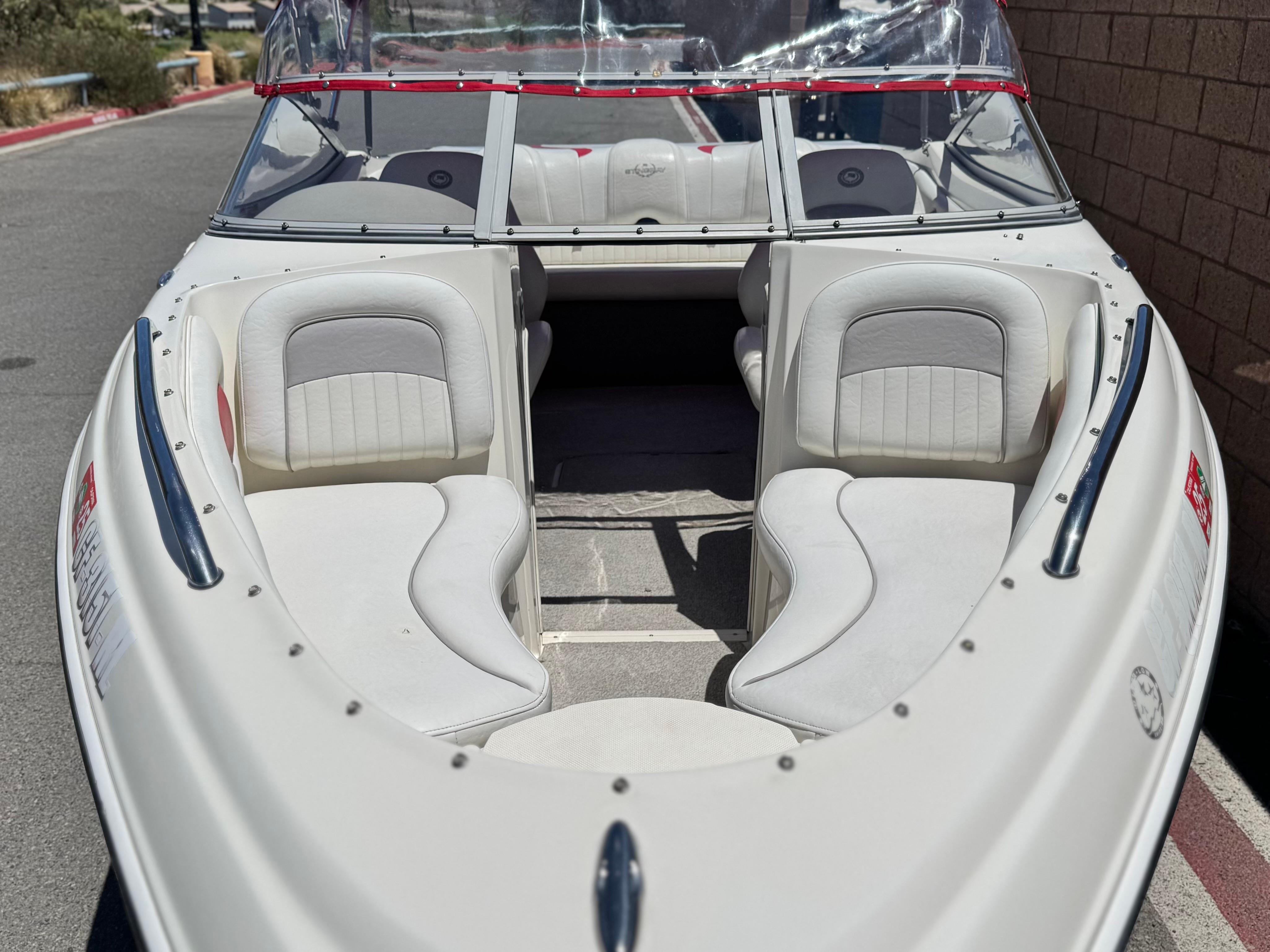 Slide: The Image of 2006 Stingray 195 LR boat with white interior and windshield, parked on a sunny day. - 8
