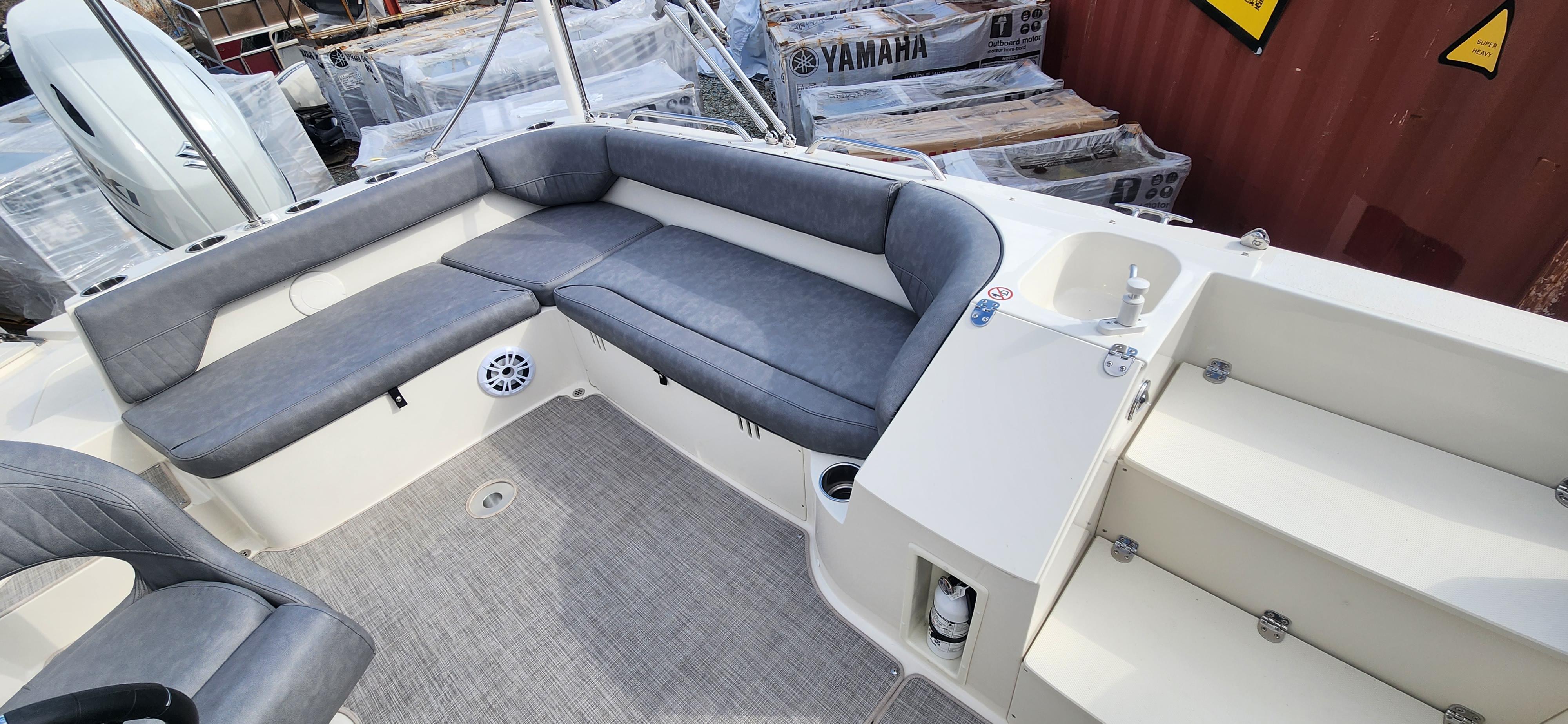 Slide: The Image of 2022 Stingray 212SC boat interior with gray seating, sink, and storage compartments. - 6