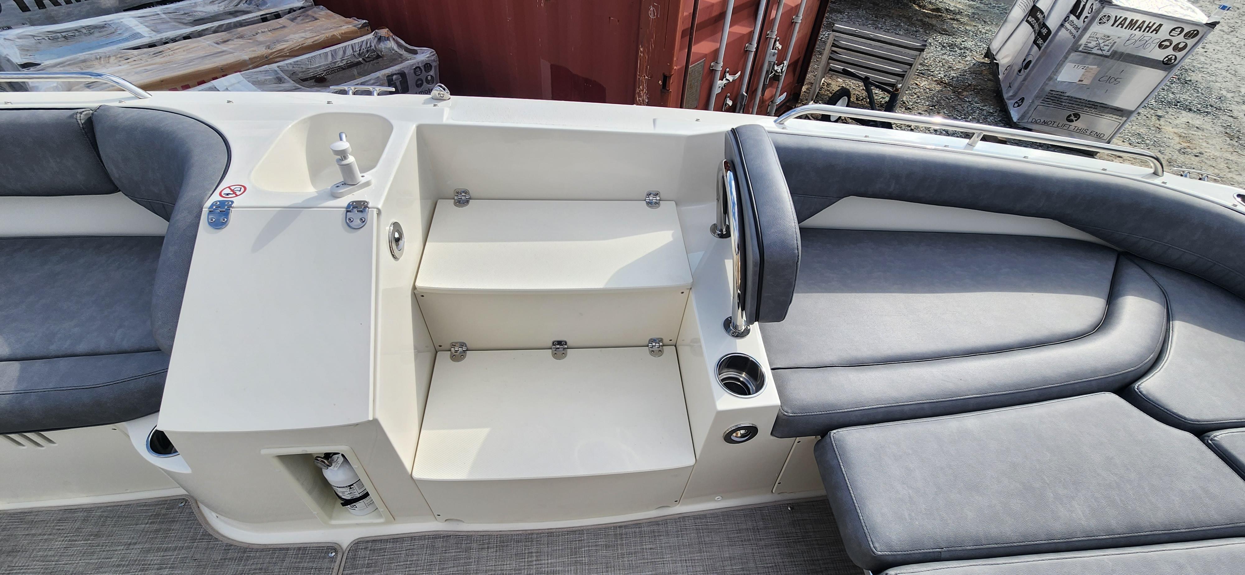 Slide: The Image of 2022 Stingray 212SC boat interior with seating, steps, and storage compartments. - 7