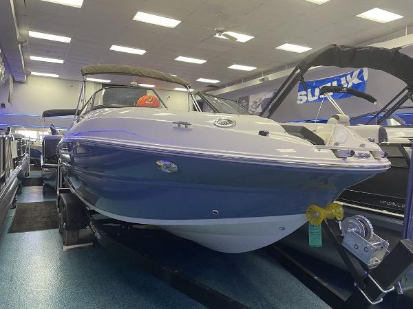 Slide: The Image of 2022 Stingray 215LR boat displayed in a showroom. - 1